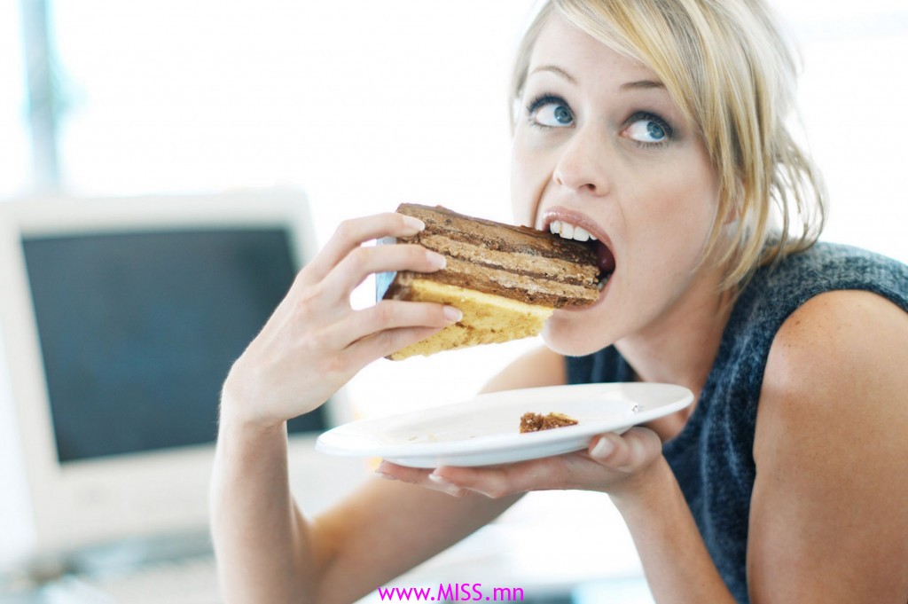 Close-up of a woman eating a large piece of cake