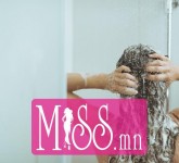 Young woman washing head with shampoo. rear view